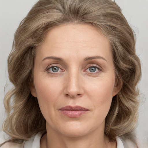 Joyful white adult female with medium  brown hair and grey eyes