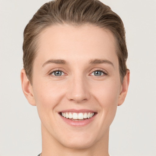 Joyful white young-adult female with short  brown hair and grey eyes