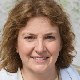 Joyful white adult female with medium  brown hair and blue eyes