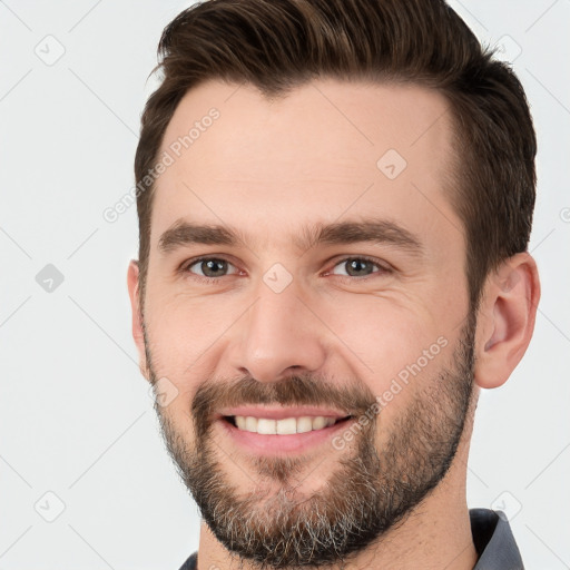 Joyful white young-adult male with short  brown hair and brown eyes