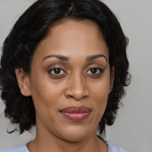 Joyful black adult female with medium  brown hair and brown eyes