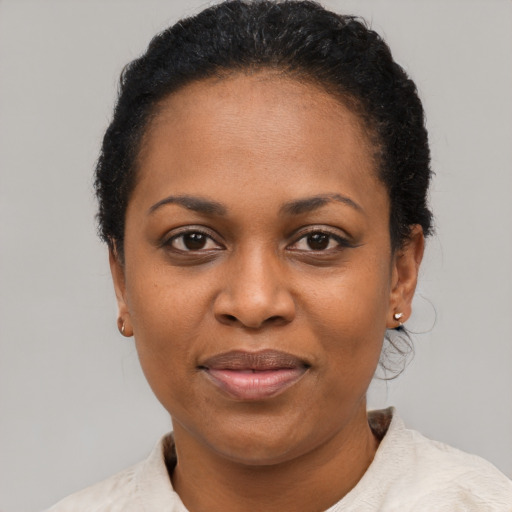Joyful black adult female with short  black hair and brown eyes