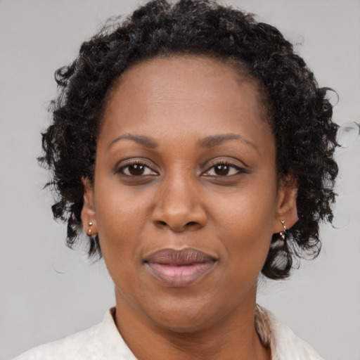 Joyful black adult female with medium  brown hair and brown eyes