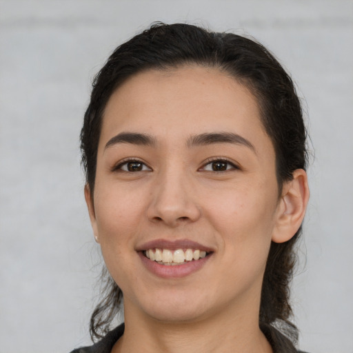 Joyful white young-adult female with long  brown hair and brown eyes