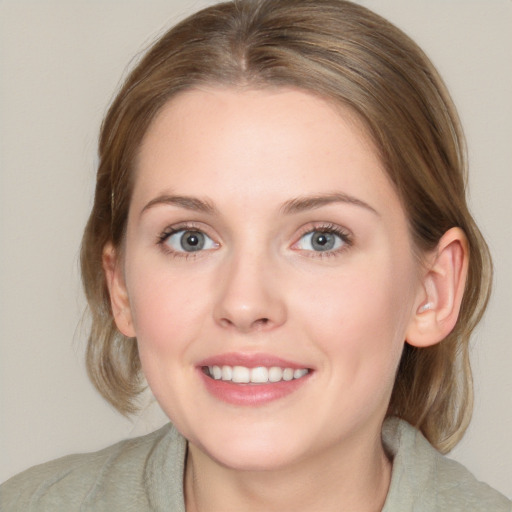 Joyful white young-adult female with medium  brown hair and blue eyes