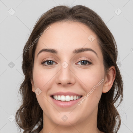 Joyful white young-adult female with long  brown hair and grey eyes