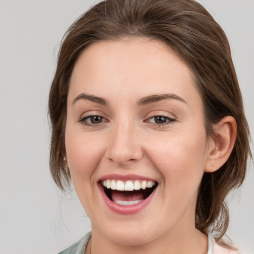 Joyful white young-adult female with medium  brown hair and grey eyes