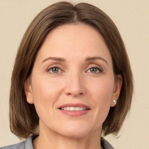 Joyful white adult female with medium  brown hair and grey eyes