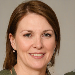 Joyful white adult female with medium  brown hair and green eyes