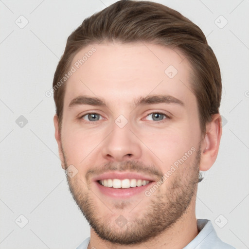 Joyful white young-adult male with short  brown hair and grey eyes