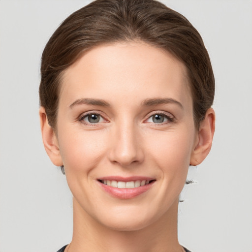 Joyful white young-adult female with short  brown hair and grey eyes