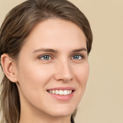 Joyful white young-adult female with long  brown hair and grey eyes