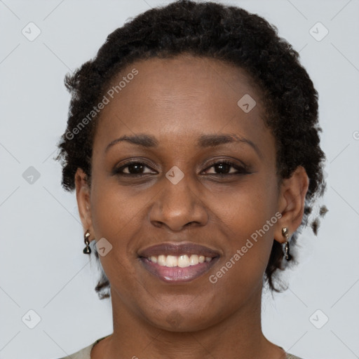 Joyful black young-adult female with long  brown hair and brown eyes