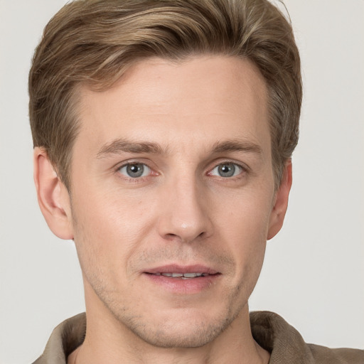 Joyful white young-adult male with short  brown hair and grey eyes