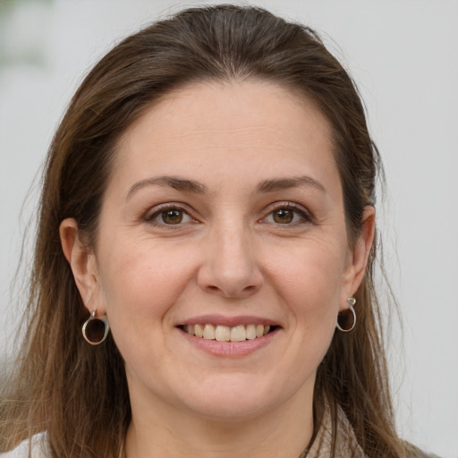 Joyful white young-adult female with long  brown hair and grey eyes