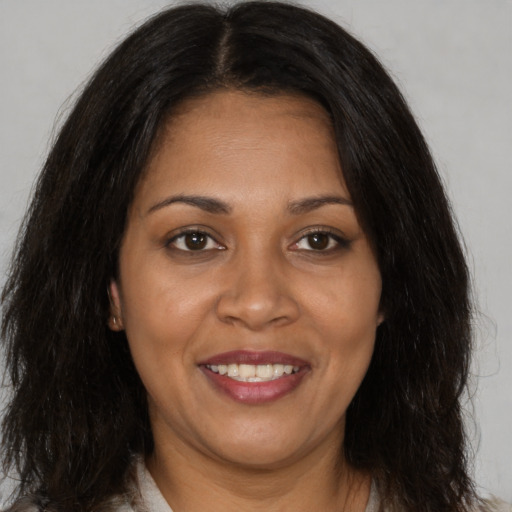 Joyful black adult female with long  brown hair and brown eyes