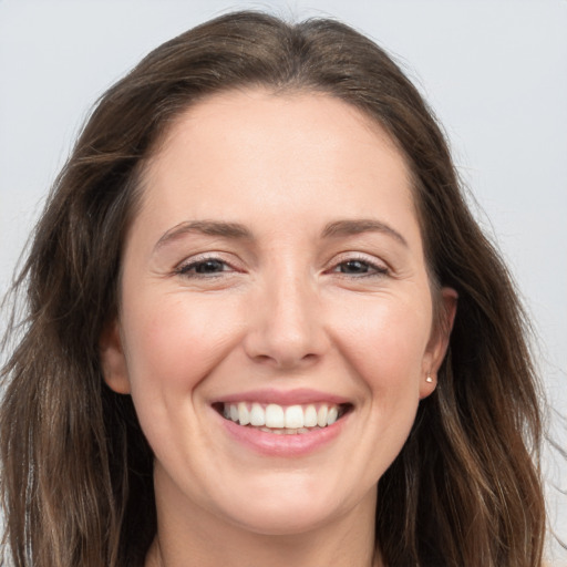 Joyful white adult female with long  brown hair and brown eyes