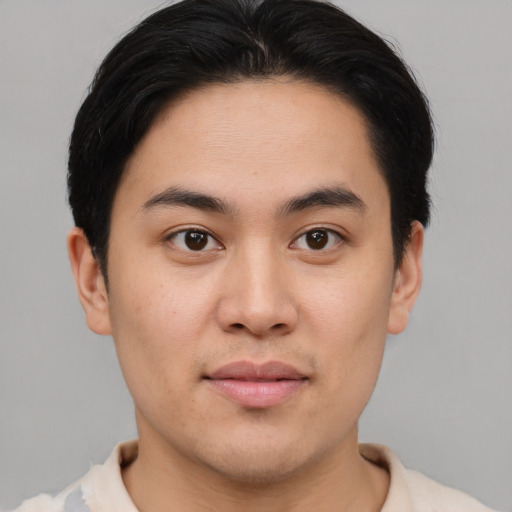 Joyful asian young-adult male with short  brown hair and brown eyes