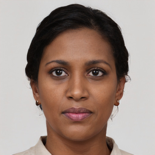 Joyful black young-adult female with short  brown hair and brown eyes