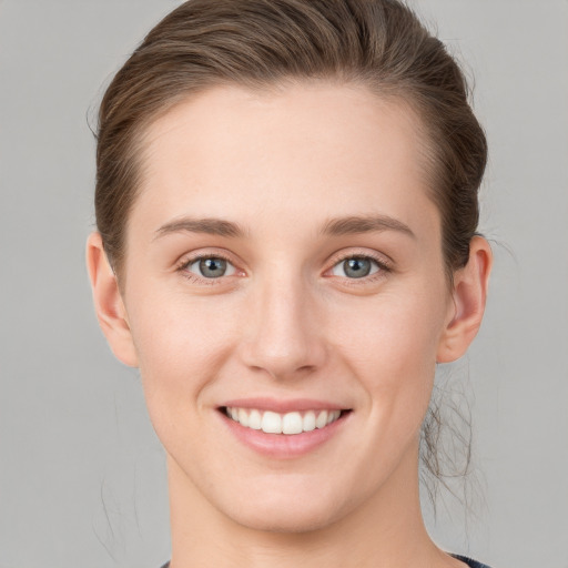 Joyful white young-adult female with short  brown hair and grey eyes