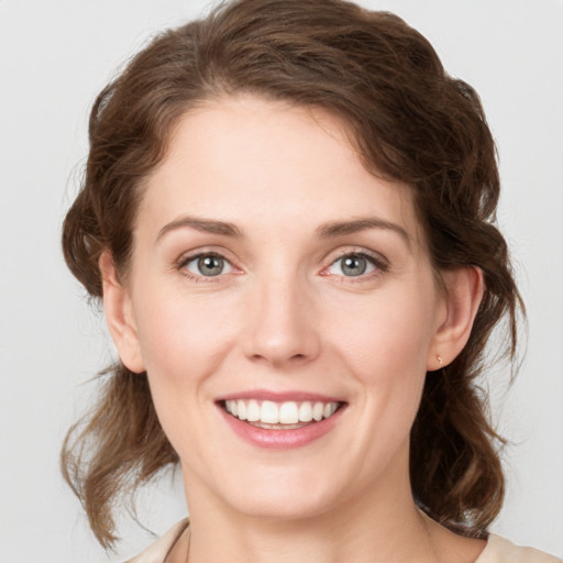 Joyful white young-adult female with medium  brown hair and green eyes