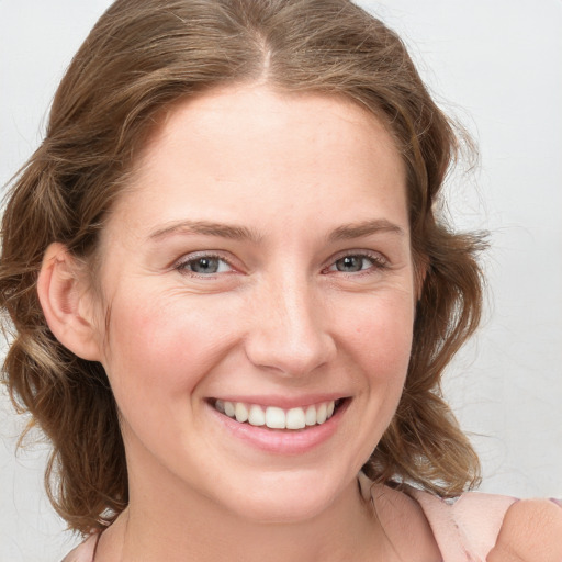 Joyful white young-adult female with medium  brown hair and blue eyes