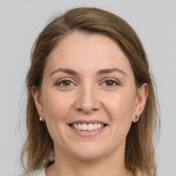 Joyful white young-adult female with medium  brown hair and grey eyes