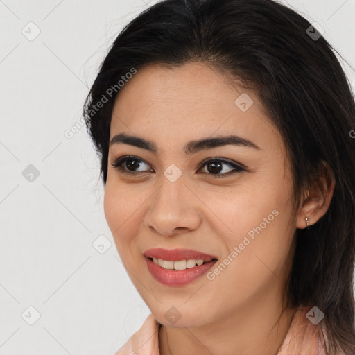 Joyful latino young-adult female with medium  brown hair and brown eyes