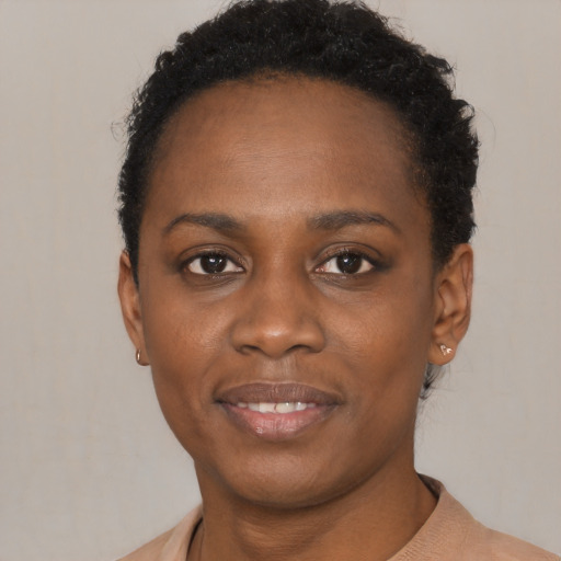 Joyful black young-adult female with short  brown hair and brown eyes