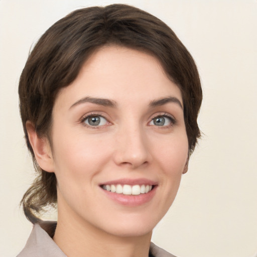 Joyful white young-adult female with medium  brown hair and grey eyes