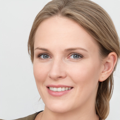 Joyful white young-adult female with medium  brown hair and grey eyes