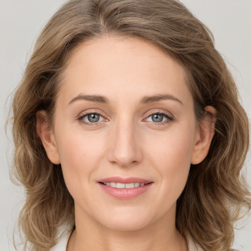 Joyful white young-adult female with long  brown hair and blue eyes