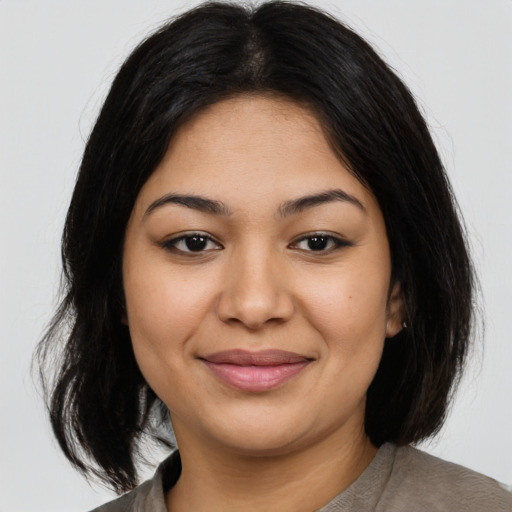 Joyful latino young-adult female with medium  brown hair and brown eyes