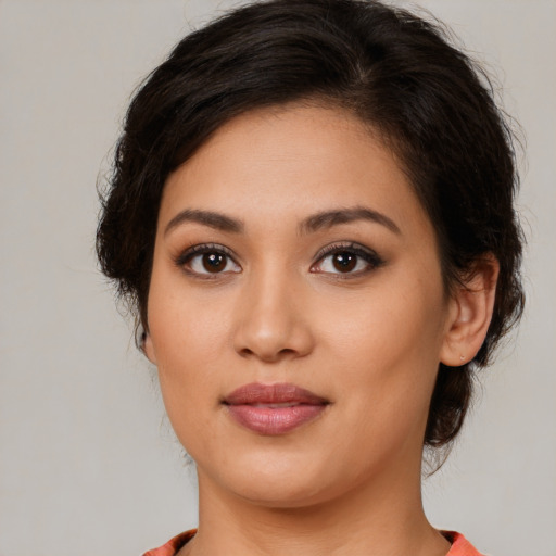 Joyful latino young-adult female with medium  brown hair and brown eyes