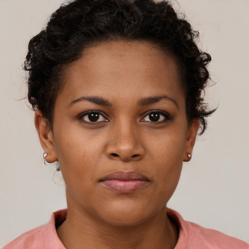 Joyful black young-adult female with short  brown hair and brown eyes