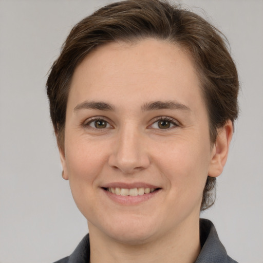 Joyful white young-adult female with short  brown hair and grey eyes