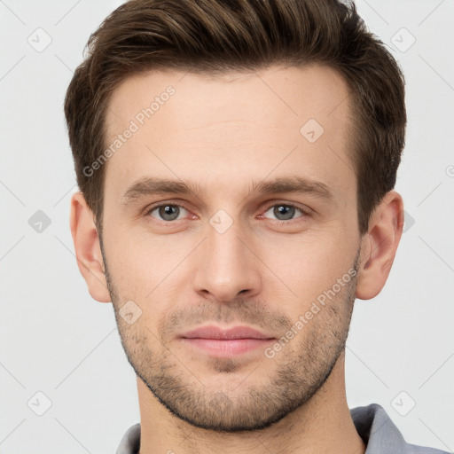 Joyful white young-adult male with short  brown hair and grey eyes