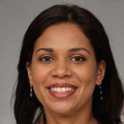 Joyful latino adult female with long  brown hair and brown eyes