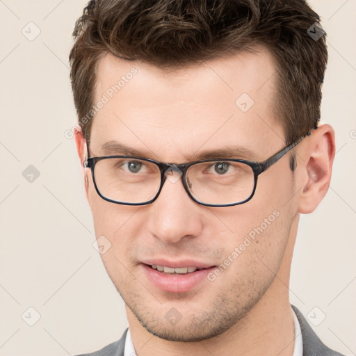 Joyful white young-adult male with short  brown hair and brown eyes