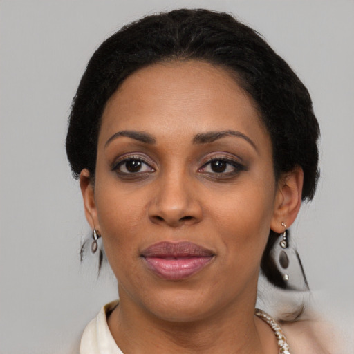 Joyful latino adult female with medium  black hair and brown eyes
