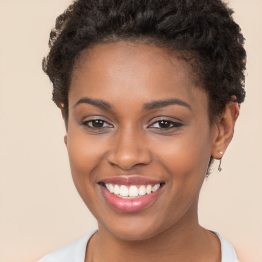 Joyful black young-adult female with short  brown hair and brown eyes