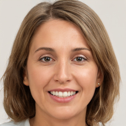 Joyful white young-adult female with medium  brown hair and green eyes