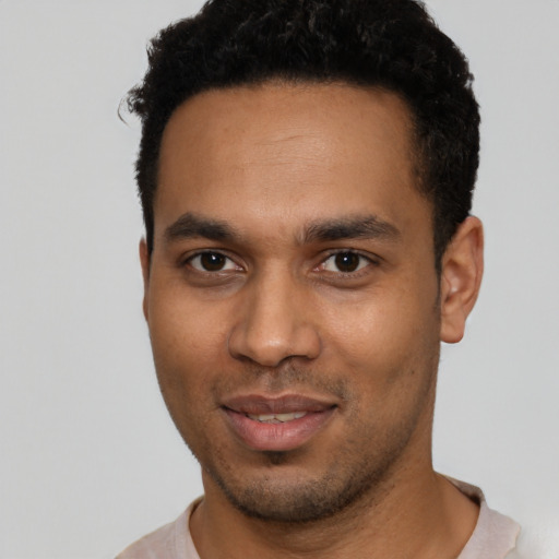 Joyful black young-adult male with short  black hair and brown eyes