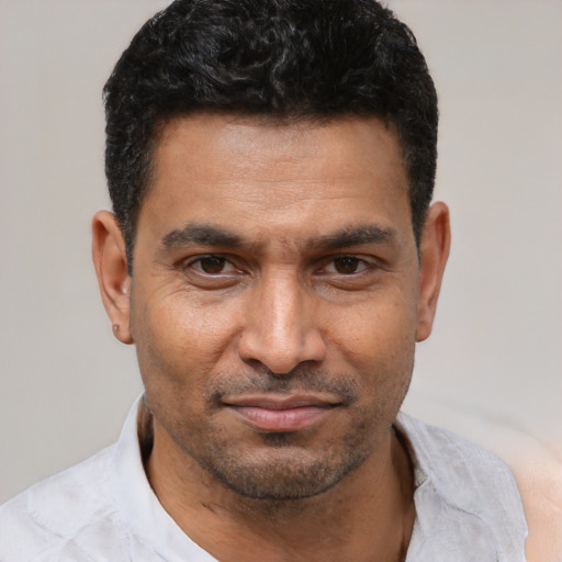 Joyful latino adult male with short  black hair and brown eyes