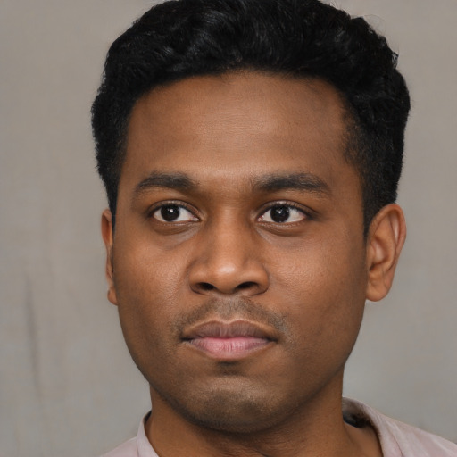 Joyful black young-adult male with short  black hair and brown eyes