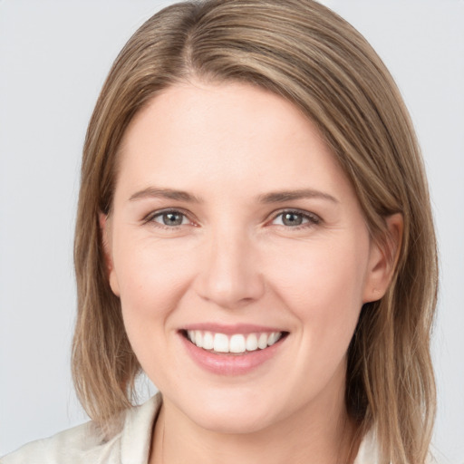 Joyful white young-adult female with medium  brown hair and grey eyes