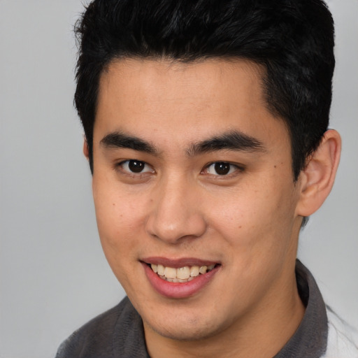 Joyful asian young-adult male with short  brown hair and brown eyes