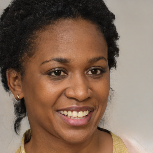 Joyful black young-adult female with short  brown hair and brown eyes