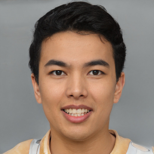 Joyful latino young-adult male with short  black hair and brown eyes