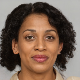 Joyful black adult female with medium  brown hair and brown eyes